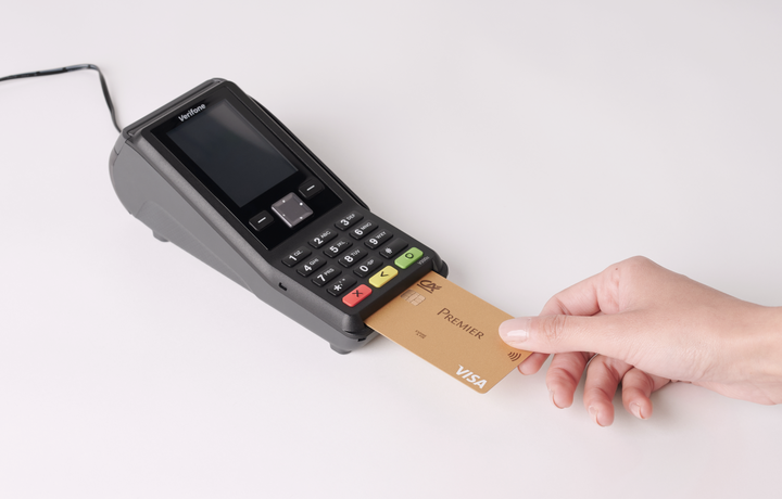 Terminal de paiement avec fil et avec main insérant une carte gold